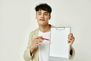 portrait of a young man in a beige suit copy-space notebook light background unaltered photo