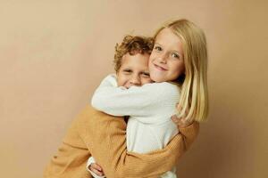 Boy and girl standing next to posing emotions beige background photo