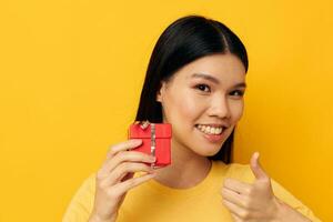 Charming young Asian woman in a yellow t-shirt holiday gift emotions Monochrome shot photo