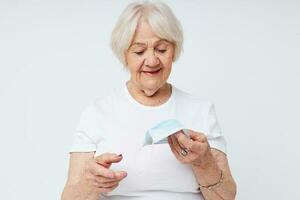 Portrait of an old friendly woman in casual t-shirt and medical mask isolated background photo