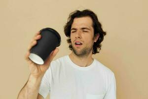 hermoso hombre con un negro vaso en un blanco camiseta aislado antecedentes foto