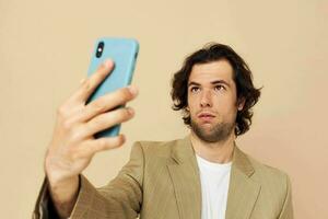 Cheerful man takes a selfie classic style technologies beige background photo