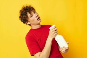 guy with red curly hair in a red t-shirt detergents in hands posing Lifestyle unaltered photo