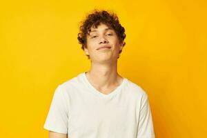 Cheerful guy with curly hair in a white T-shirt Youth style photo