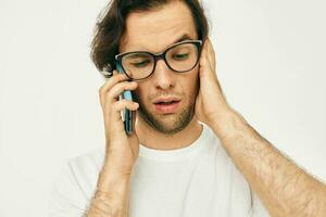 Attractive man in a white T-shirt communication by phone isolated background photo