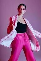 Young beautiful woman plaid blazer fashion posing luxury pink background unaltered photo