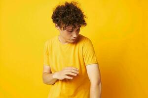 chico con rojo Rizado pelo amarillo camiseta Moda mano gestos aislado antecedentes inalterado foto