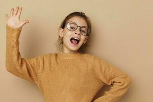 Portrait of happy smiling child girl with glasses emotions gesture hands Lifestyle unaltered photo