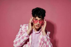 foto de romántico joven novio en rosado lentes rosado chaqueta de sport posando estudio rosado antecedentes inalterado