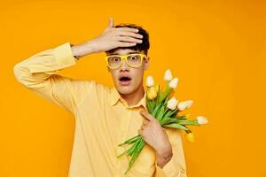 handsome guy give flowers wear spectacles yellow shirt isolated background unaltered photo