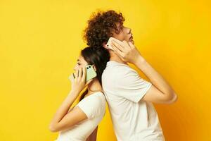 young couple talking on the phone yellow technology background photo