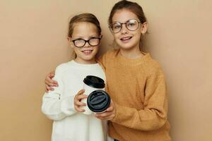 little girls hugging together glass with drink photo