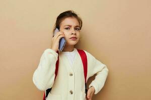 Portrait of happy smiling child girl schoolgirl backpack phone in hand childhood unaltered photo