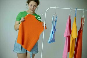 cheerful woman trying on clothes wardrobe Youth style light background unaltered photo