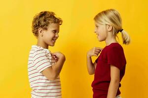 chico y niña en pie lado por lado posando infancia emociones en de colores antecedentes foto