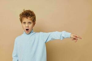 curly boy in a blue sweater posing fun childhood unaltered photo