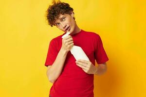 Young curly-haired man detergent posing emotion yellow background unaltered photo