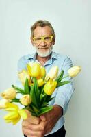 old man a bouquet of flowers with glasses as a gift light background photo