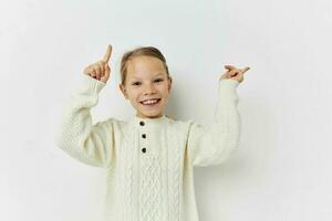 cheerful little girl in a white sweater hand gesture photo