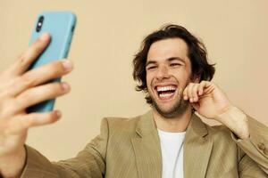 man with a phone in hand beige suit elegant style isolated background photo