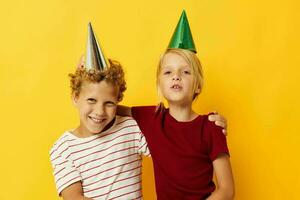 retrato de linda niños en casual ropa con tapas en el cabeza en de colores antecedentes foto