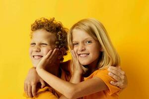 picture of positive boy and girl cuddling fashion childhood entertainment on colored background photo