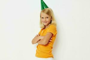 un niña con un verde gorra en su cabeza gestos con su manos foto