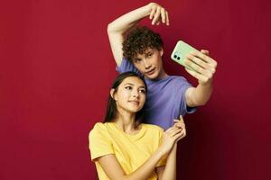 nice guy and girl in colorful T-shirts with a phone Youth style photo