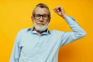 Portrait elderly man with glasses safety medical mask posing yellow background photo