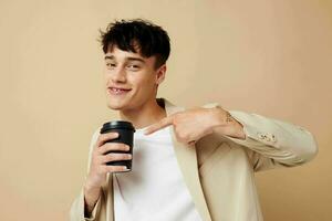 A young man a glass with a drink in hand modern style isolated background unaltered photo