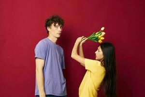 cute young couple gift bouquet of flowers fun red background unaltered photo
