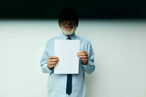 elderly man holding documents with a sheet of paper light background photo