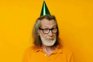 retrato de contento mayor hombre vistiendo lentes verde gorra en su cabeza fiesta emociones inalterado foto