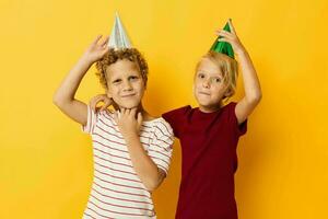 Portrait of cute children in casual clothes with caps on the head on colored background photo