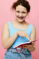 teenager girl in a blue T-shirt with a red notepad and a pen of emotions isolated background unaltered photo