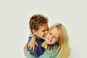 Photo of two children in multi-colored sweaters posing for fun childhood unaltered