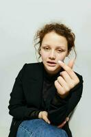 bonito mujer sentado en un silla en un negro chaqueta Moda posando ligero antecedentes inalterado foto