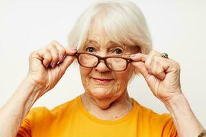 elderly woman in casual t-shirt and glasses light background photo