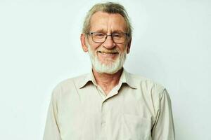 Senior grey-haired man with a gray beard in a shirt and glasses light background photo