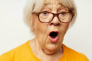 elderly woman in casual t-shirt and glasses light background photo