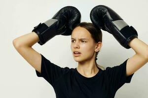 beautiful girl in boxing gloves in black pants and a T-shirt fitness training photo