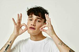 portrait of a young man modern youth style white t-shirt tattoo on the arm model studio photo