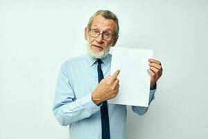 elderly man holding documents with a sheet of paper light background photo