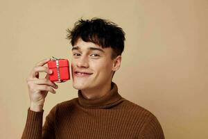 portrait of a young man stylish hairstyle brown turtleneck gift box isolated background unaltered photo