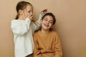 two cute little girls hug friendship beige background photo