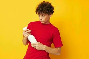 portrait of a young curly man detergents home care posing yellow background unaltered photo