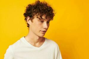 Cheerful guy with curly hair in a white T-shirt Youth style photo