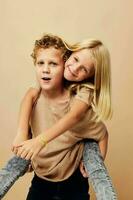 Boy and girl in beige t-shirts posing for fun childhood unaltered photo