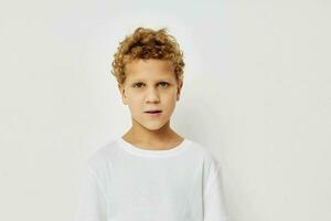 Photo of young boy in a white t-shirt posing fun childhood unaltered