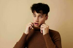 A young man stylish hairstyle brown turtleneck isolated background unaltered photo